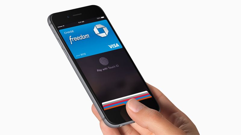 Hand, die ein iPhone mit Apple Pay-Bildschirm hält, auf dem hinzugefügte Zahlungskarten angezeigt werden