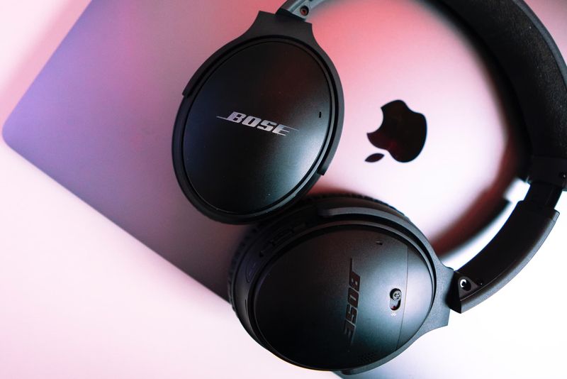 Bose-Kopfhörer werden auf einem geschlossenen MacBook aufbewahrt