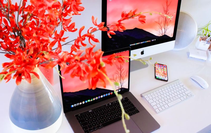iPhone, MacBook und ein iMac auf einem Schreibtisch
